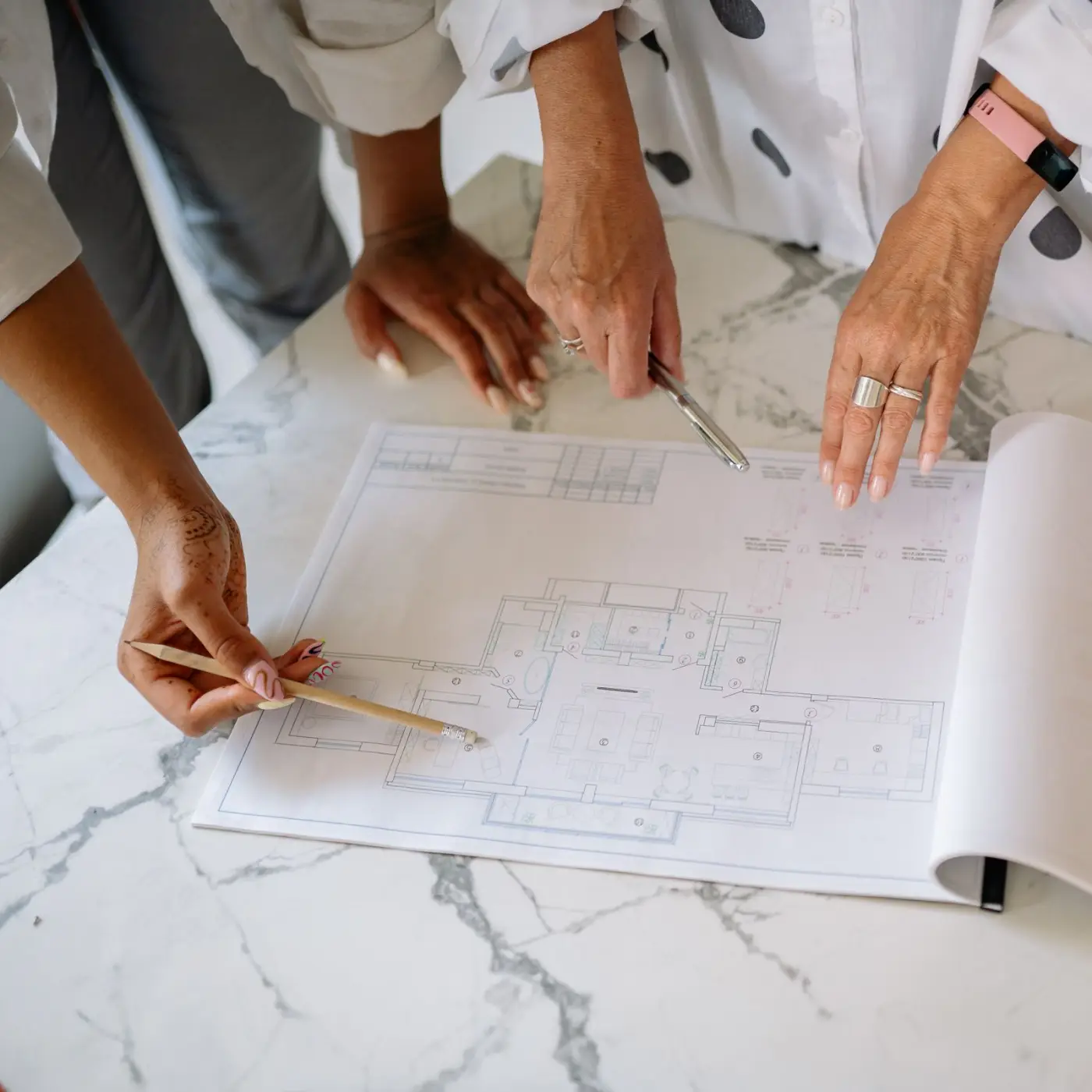 Hands drafting plans on a drawing board